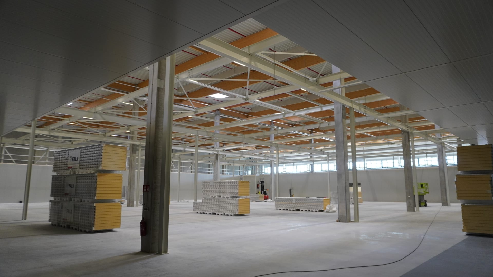 Warehouse interior with steel mezzanine frame and stacked panel packs